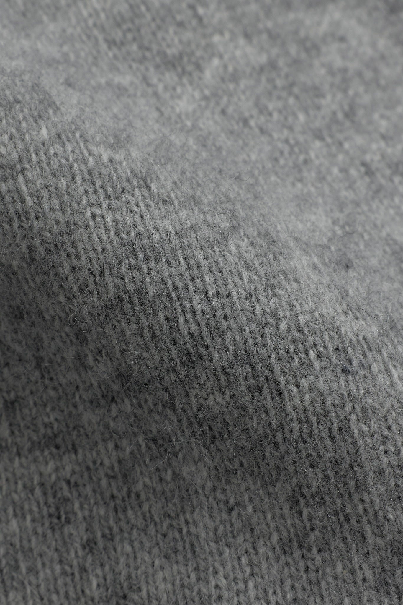 Close-up view of soft grey knitted wool fabric on a CASPARA jacket.