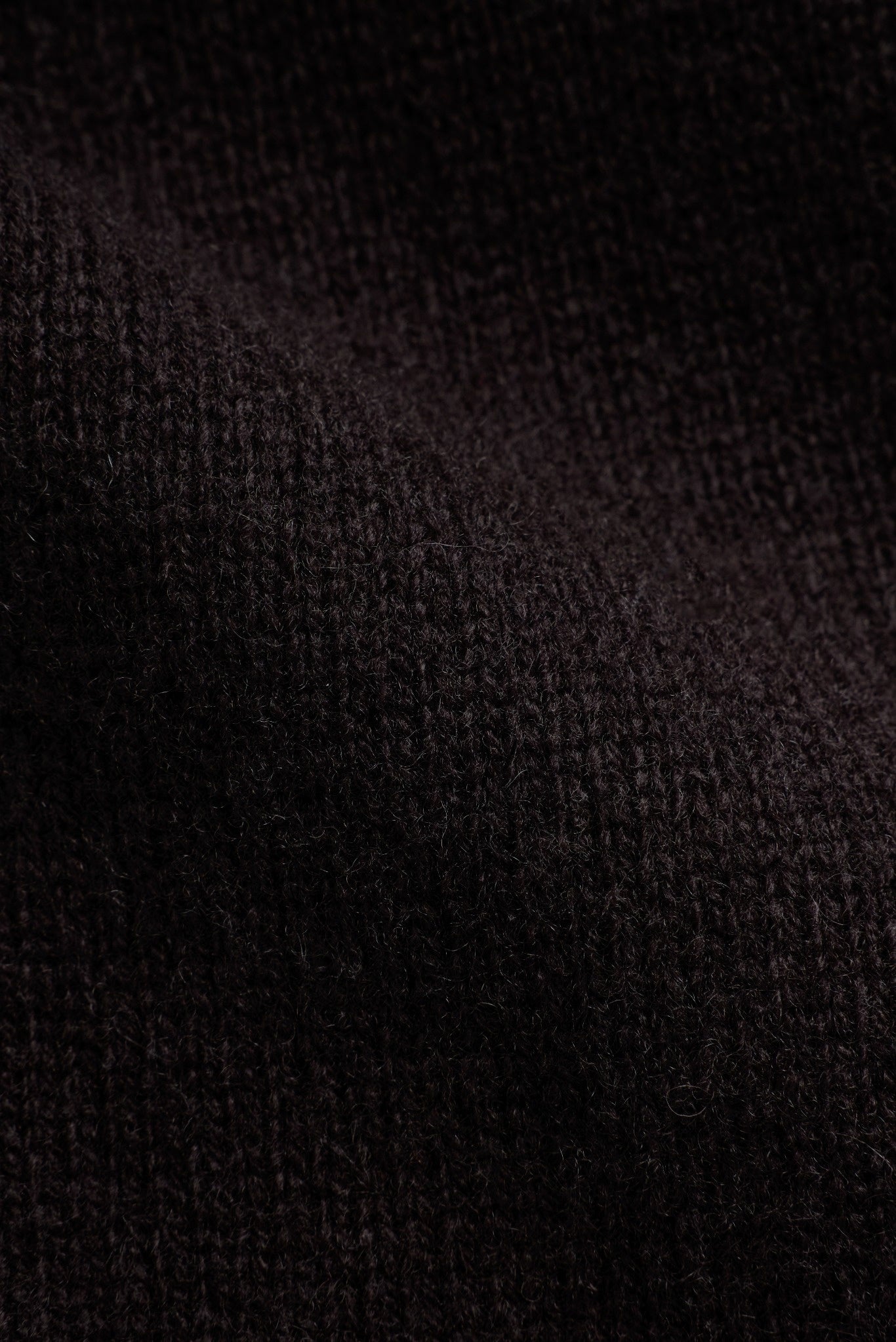 Close-up of cocoa bean wool knit fabric texture on a CASPARA jacket.