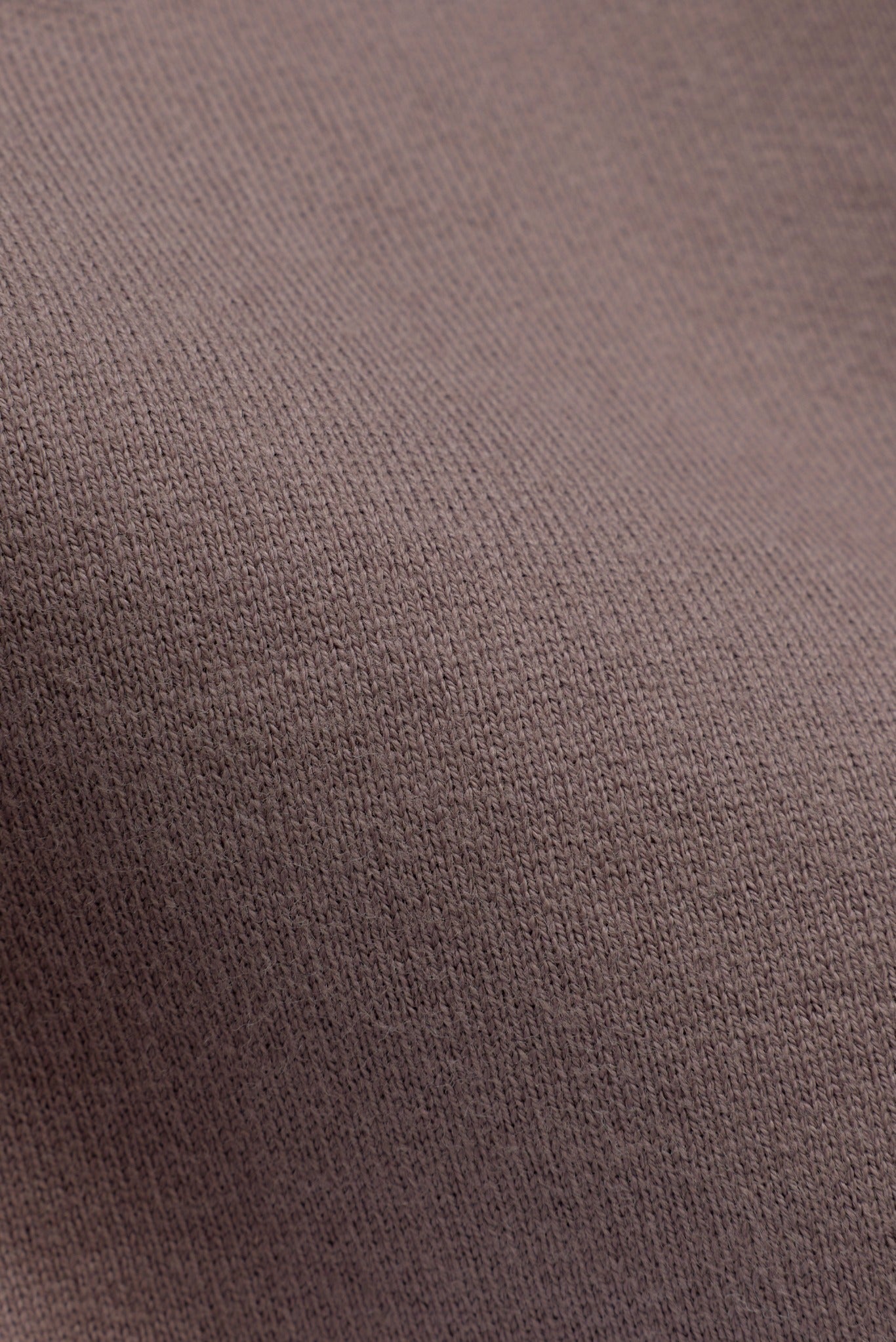 Close-up of the walnut brown cotton knit fabric texture on a CASPARA rugby shirt.