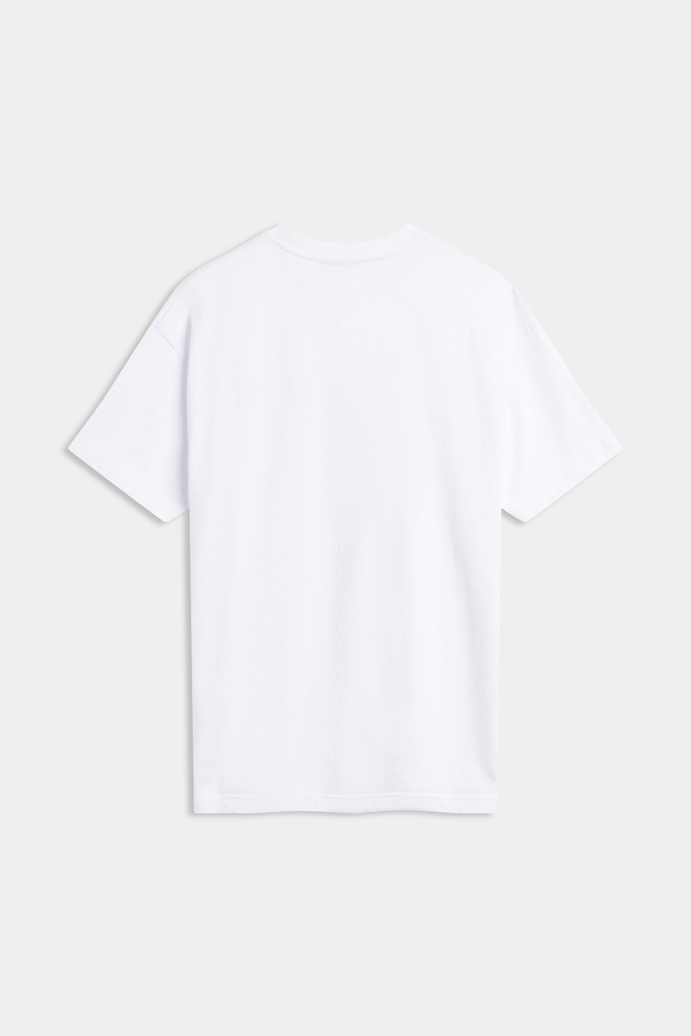Back view of a plain white oversized cotton t-shirt against a grey background.